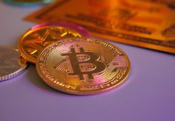 Golden bitcoin coin with other coins and card.