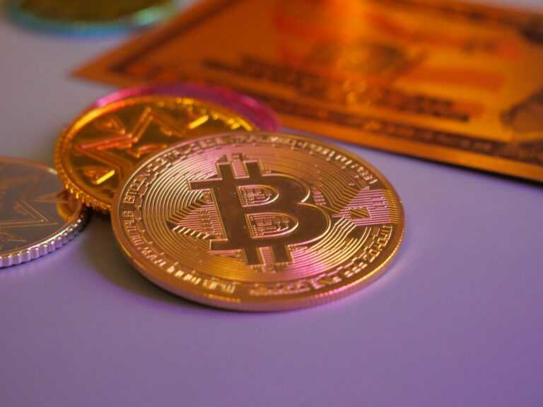 Golden bitcoin coin with other coins and card.