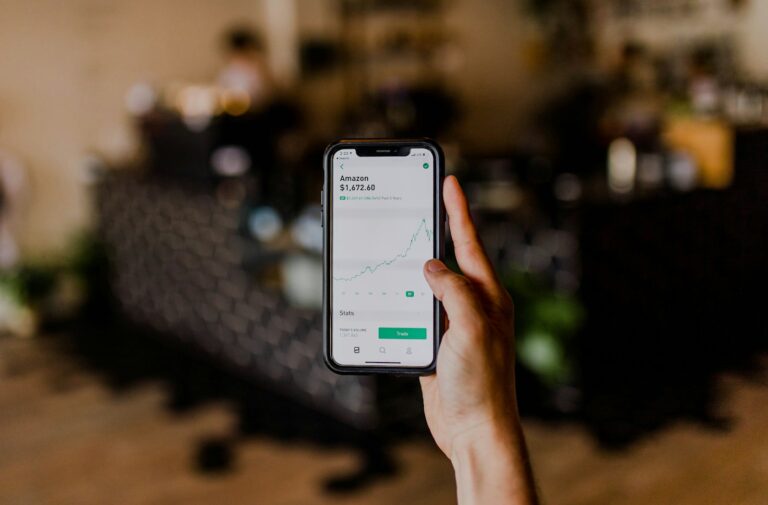 person holding black iPhone displaying stock exchange