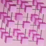 a bunch of pink cubes hanging from a pink wall