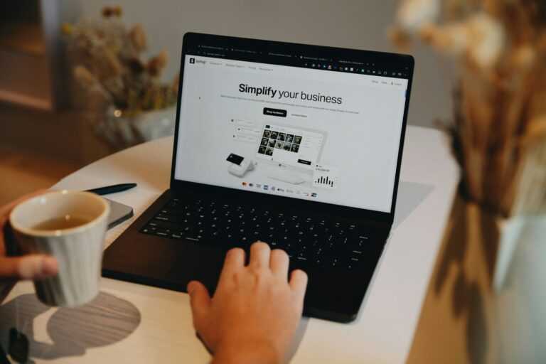 A person sitting at a table using a laptop computer